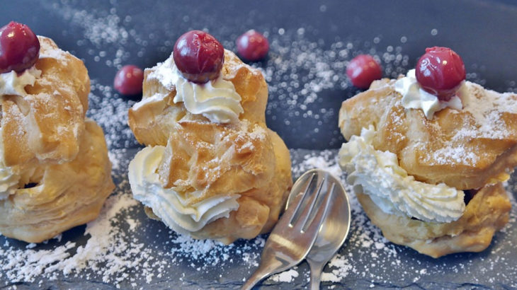 Puff pastries with whip cream and cherries
